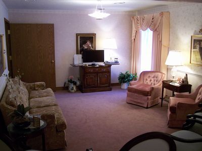 An artist 's impression of a hotel lobby with a couch , chairs , and plants.