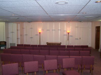 A living room with a couch , chairs , and a coffin.