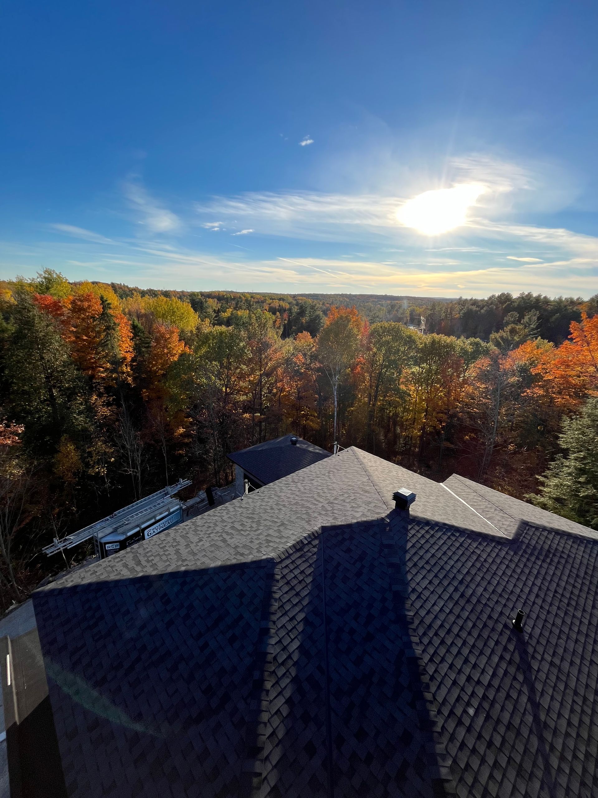Une vue aérienne d'une maison avec un toit et des arbres en arrière-plan.