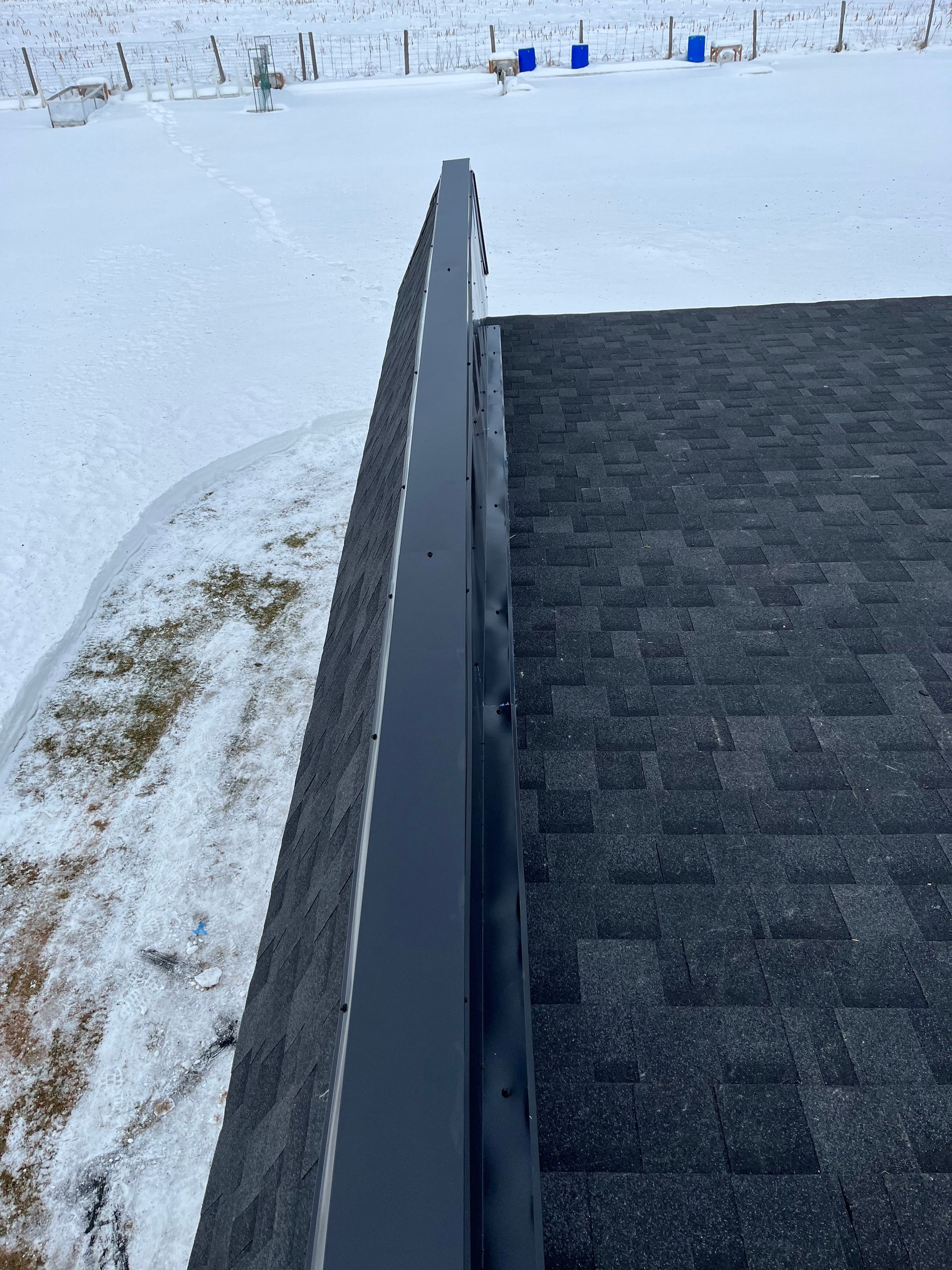 Un toit enneigé avec une gouttière noire dessus