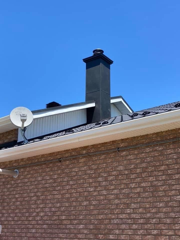 Une maison en brique avec une cheminée et une antenne parabolique sur le toit
