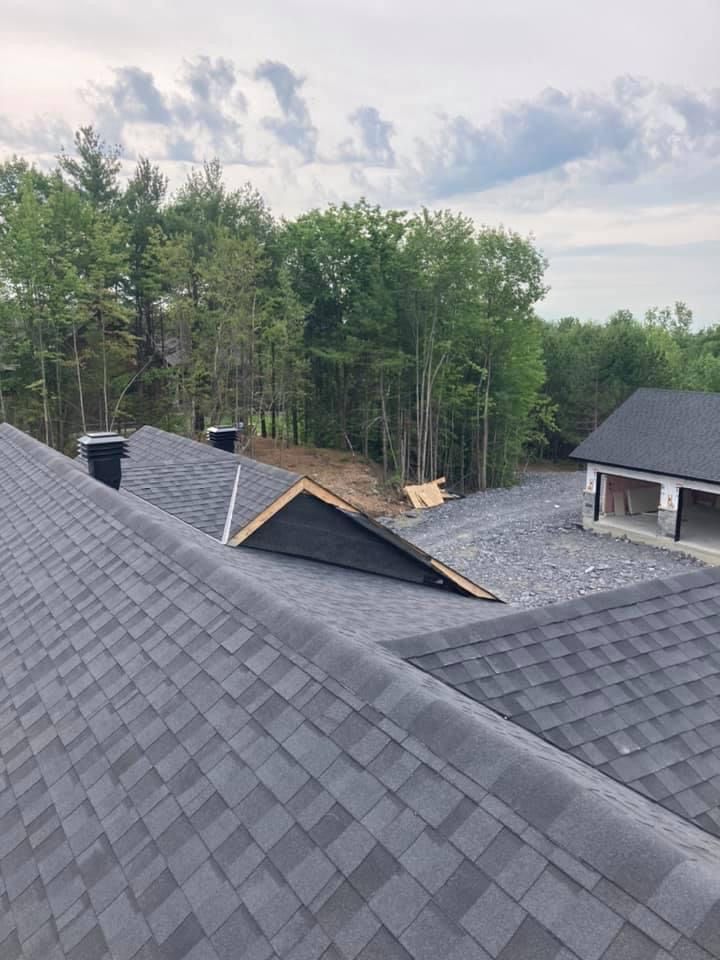 Un toit avec beaucoup de bardeaux et des arbres en arrière-plan.