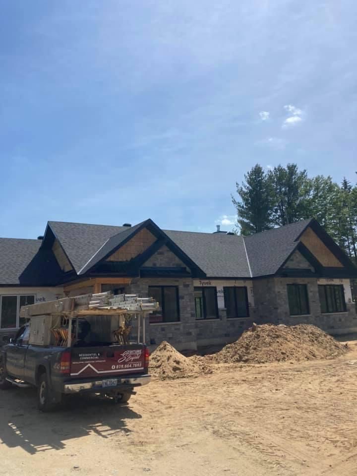 Un camion est garé devant une maison en construction.