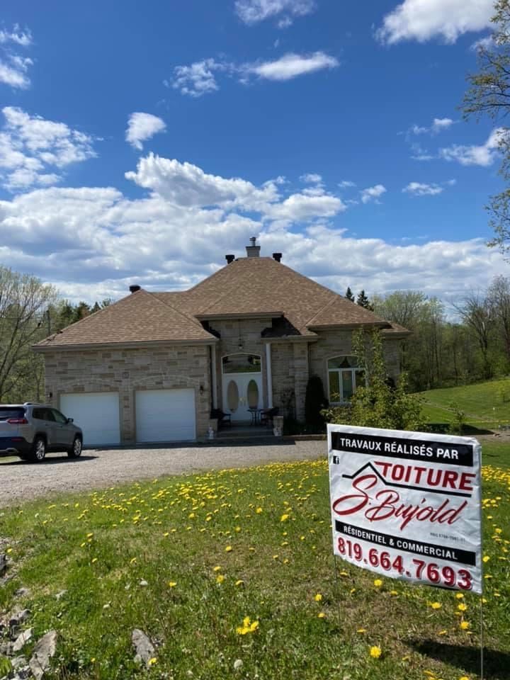 Une grande maison avec une pancarte devant.