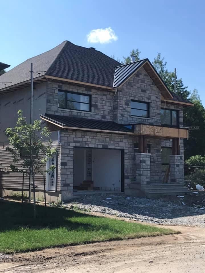 Une grande maison en brique avec un garage en construction.