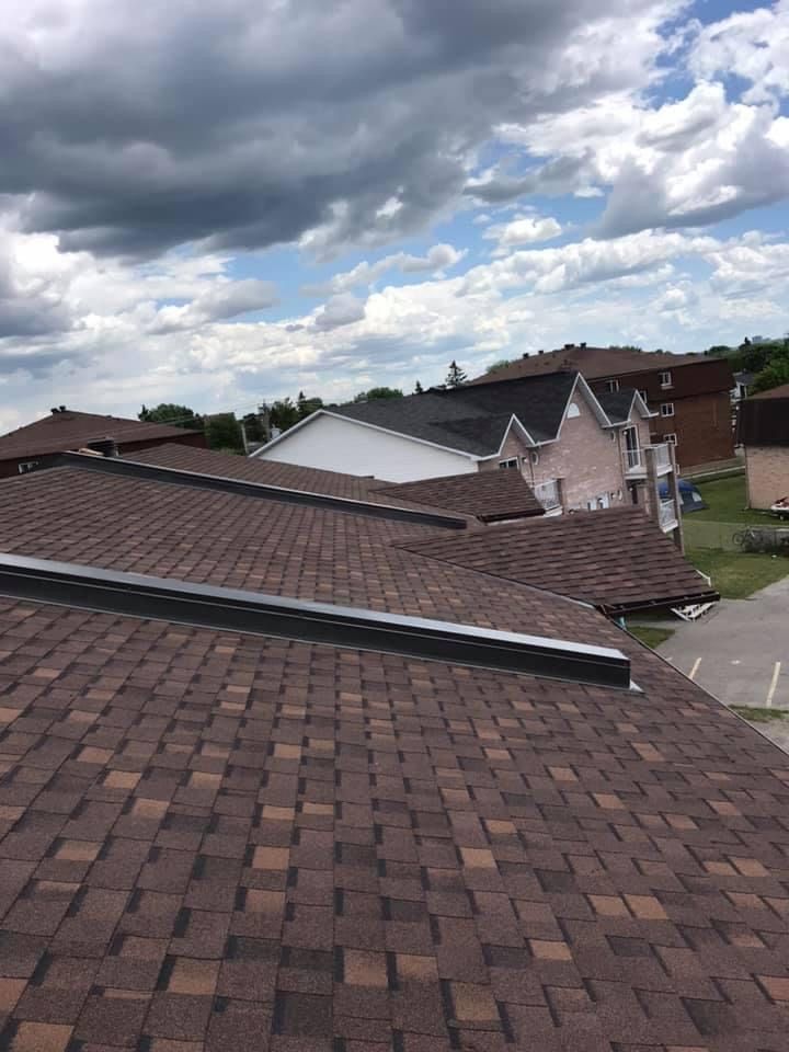 Un toit d'une maison avec un ciel nuageux en arrière-plan