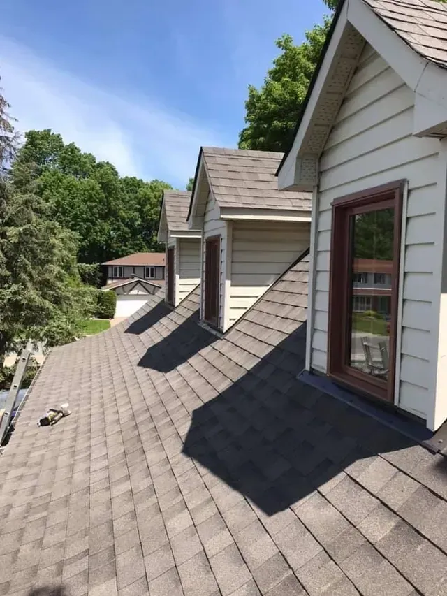 Une rangée de maisons avec un toit qui a beaucoup de fenêtres