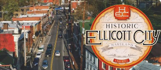 Historic Ellicott City sign over a downtown street with buildings and cars