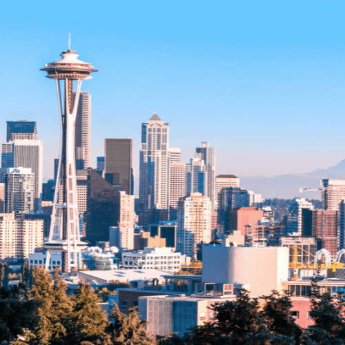 Seattle skyline with Space Needle under a clear blue sky.