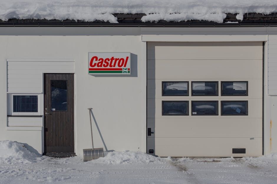 Exterior of a Castrol service station with a closed garage door and snow.