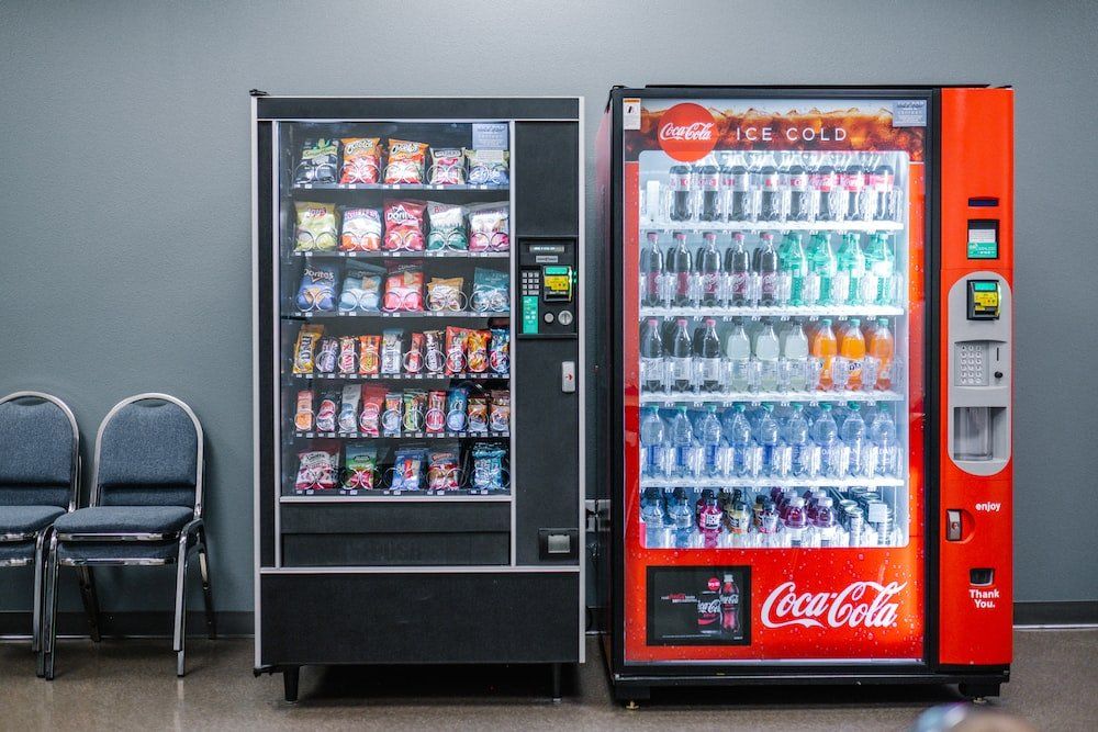 Two vending machines are sitting next to each other in a room.
