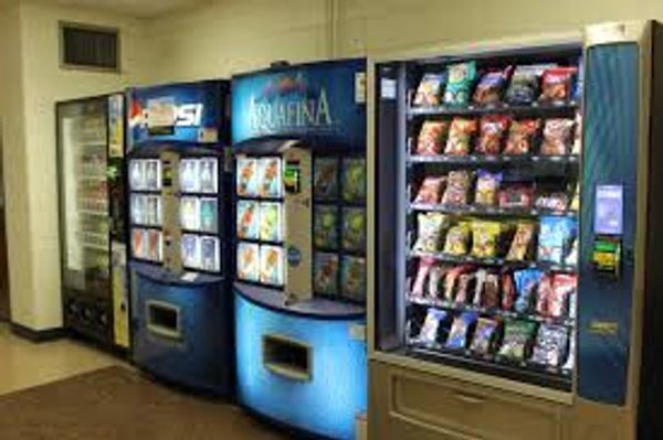 A row of vending machines are lined up in a room.