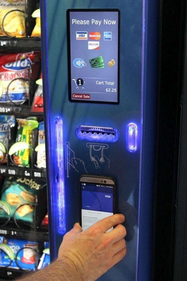 A person is using a smart phone to pay at a vending machine
