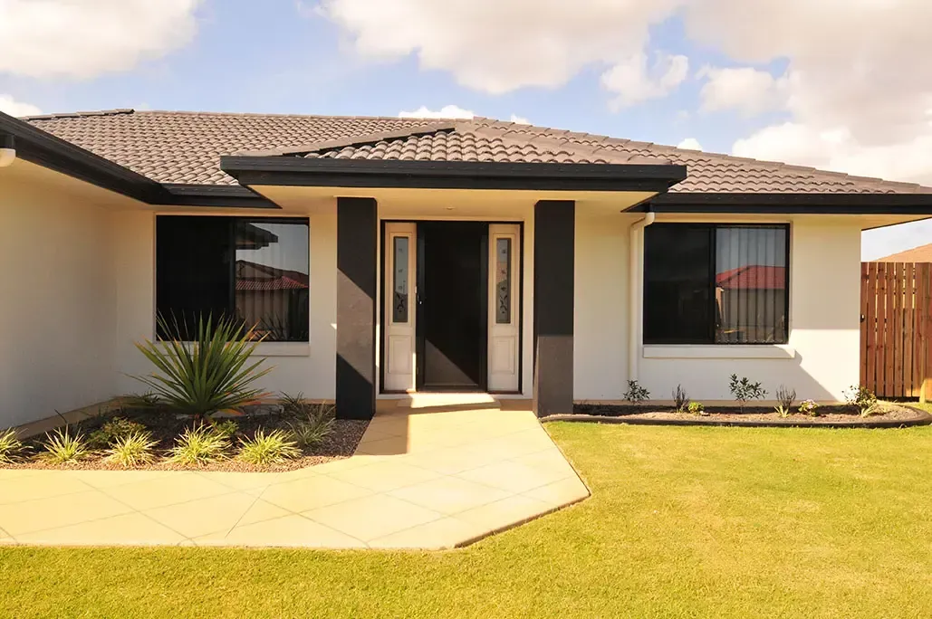 A Single-story Home With a Tan Walkway, White Walls, Dark Window Frames, and a Black Entryway — Advantage Screen And Blinds Rockhampton in Rockhampton, QLD