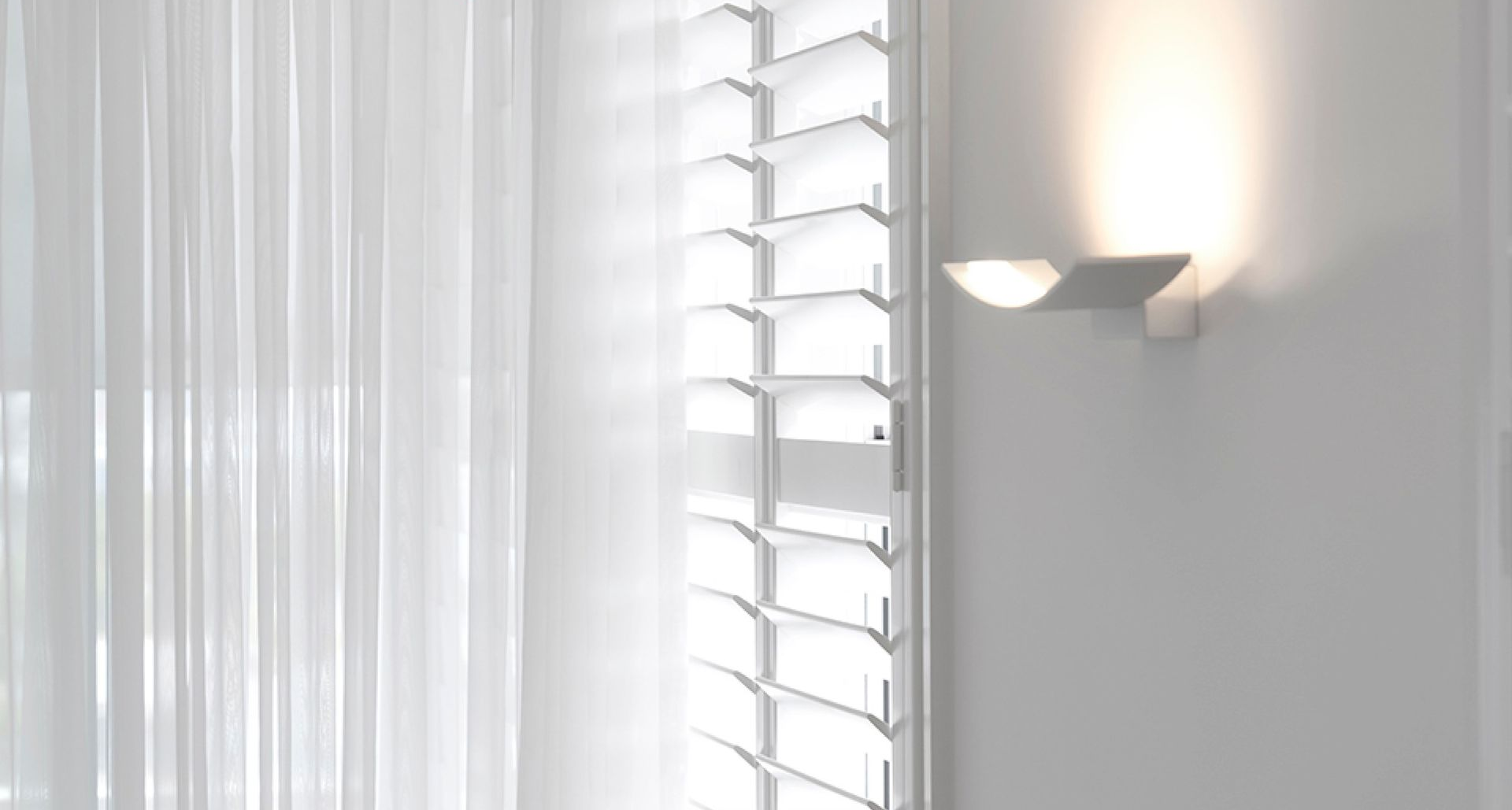 White Window Shutters Next to White Curtains in a Room — Advantage Screen And Blinds Rockhampton in Gracemere, QLD
