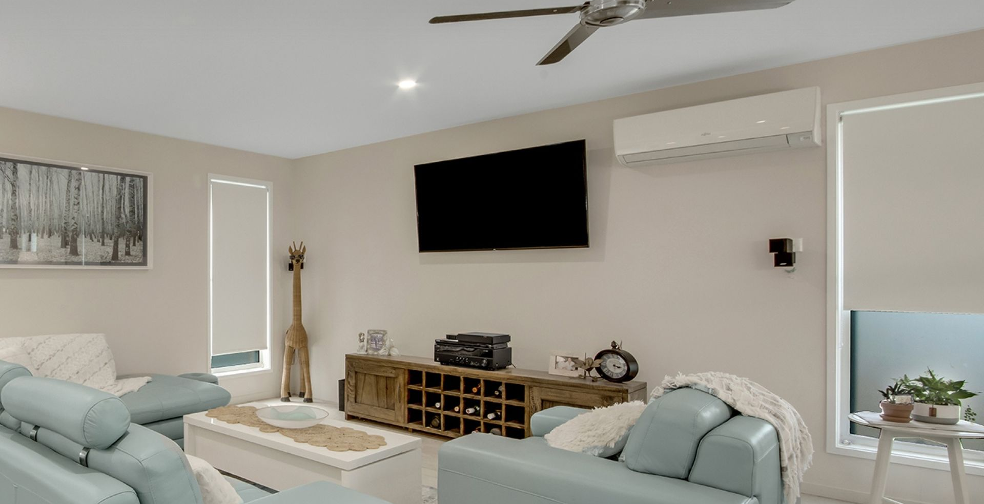 A Living Room With Light Blue Sofas, a Flat-screen TV — Advantage Screen And Blinds Rockhampton in Gracemere, QLD