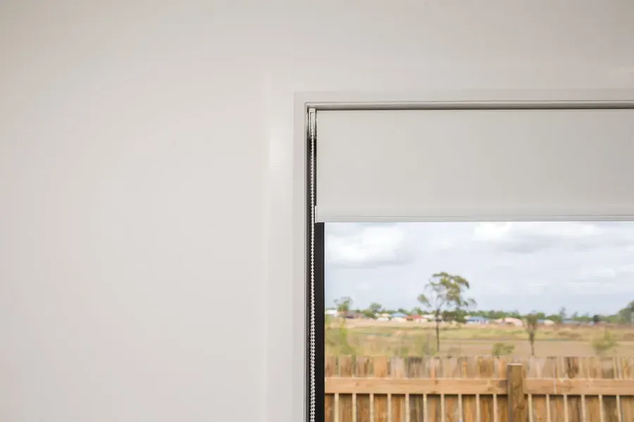 A Partially Drawn White Roller Blind on a Window — Advantage Screen And Blinds Rockhampton in Rockhampton, QLD