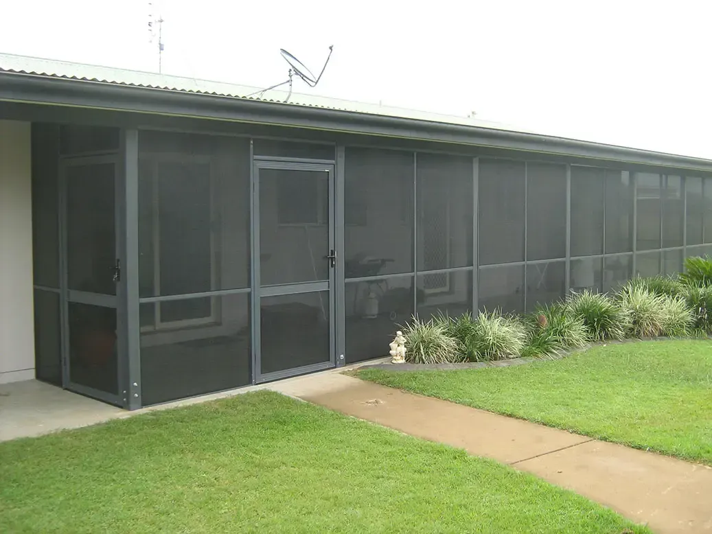 Enclosed Patio With Dark Mesh Screens Attached to a Single-story House — Advantage Screen And Blinds Rockhampton in Rockhampton, QLD