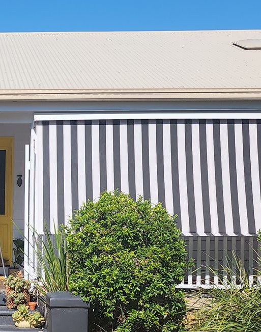 An Aerial View of a White Home With Black and White Striped Awnings — Advantage Screen And Blinds Rockhampton in Rockhampton, QLD