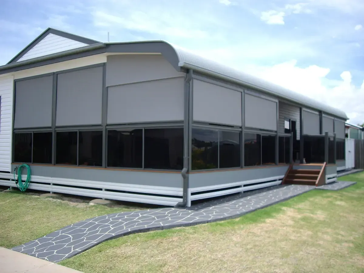A House Featuring a Grey-walled Deck Enclosed by Dark, Tinted Glass Windows and Retractable Shades — Advantage Screen And Blinds Rockhampton in Rockhampton, QLD