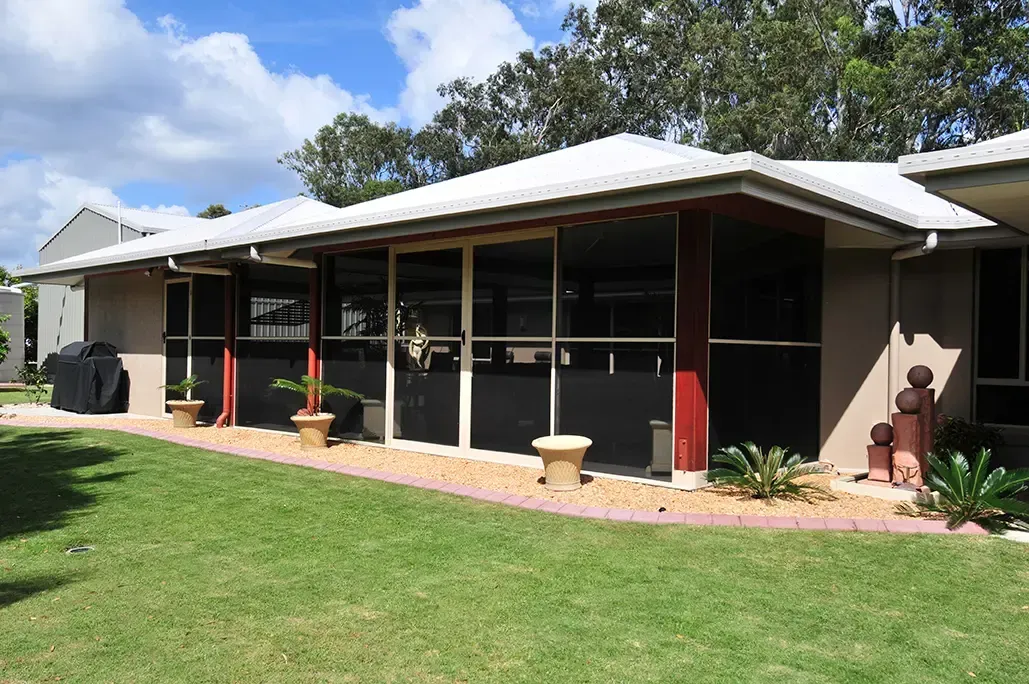 House With a White Roof, Large Screened Porch, and a Well-kept Lawn — Advantage Screen And Blinds Rockhampton in Rockhampton, QLD