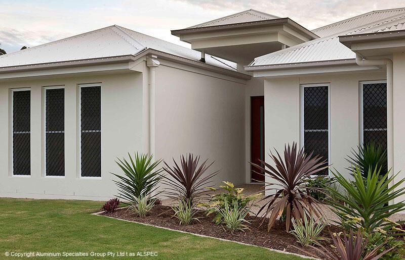 Modern single-story house exterior with white walls, dark windows, and landscaped front yard — Advantage Screen And Blinds Rockhampton in Rockhampton, QLD