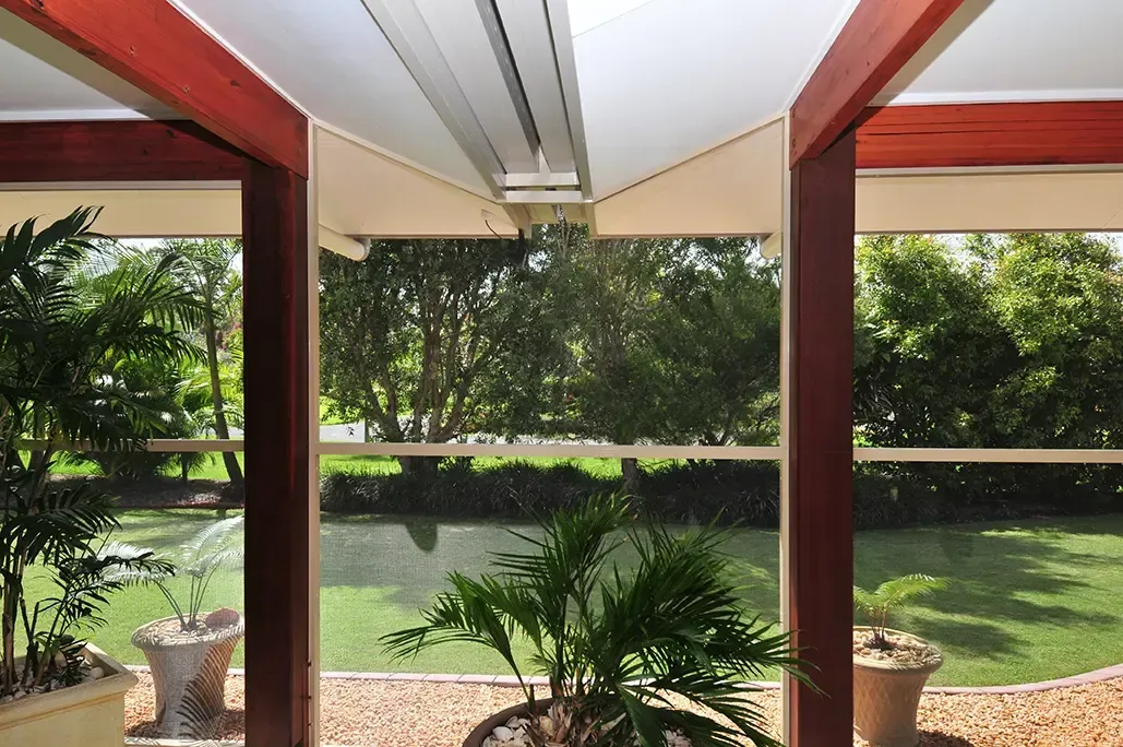 View Through a Covered Patio With Dark Wooden Posts — Advantage Screen And Blinds Rockhampton in Rockhampton, QLD