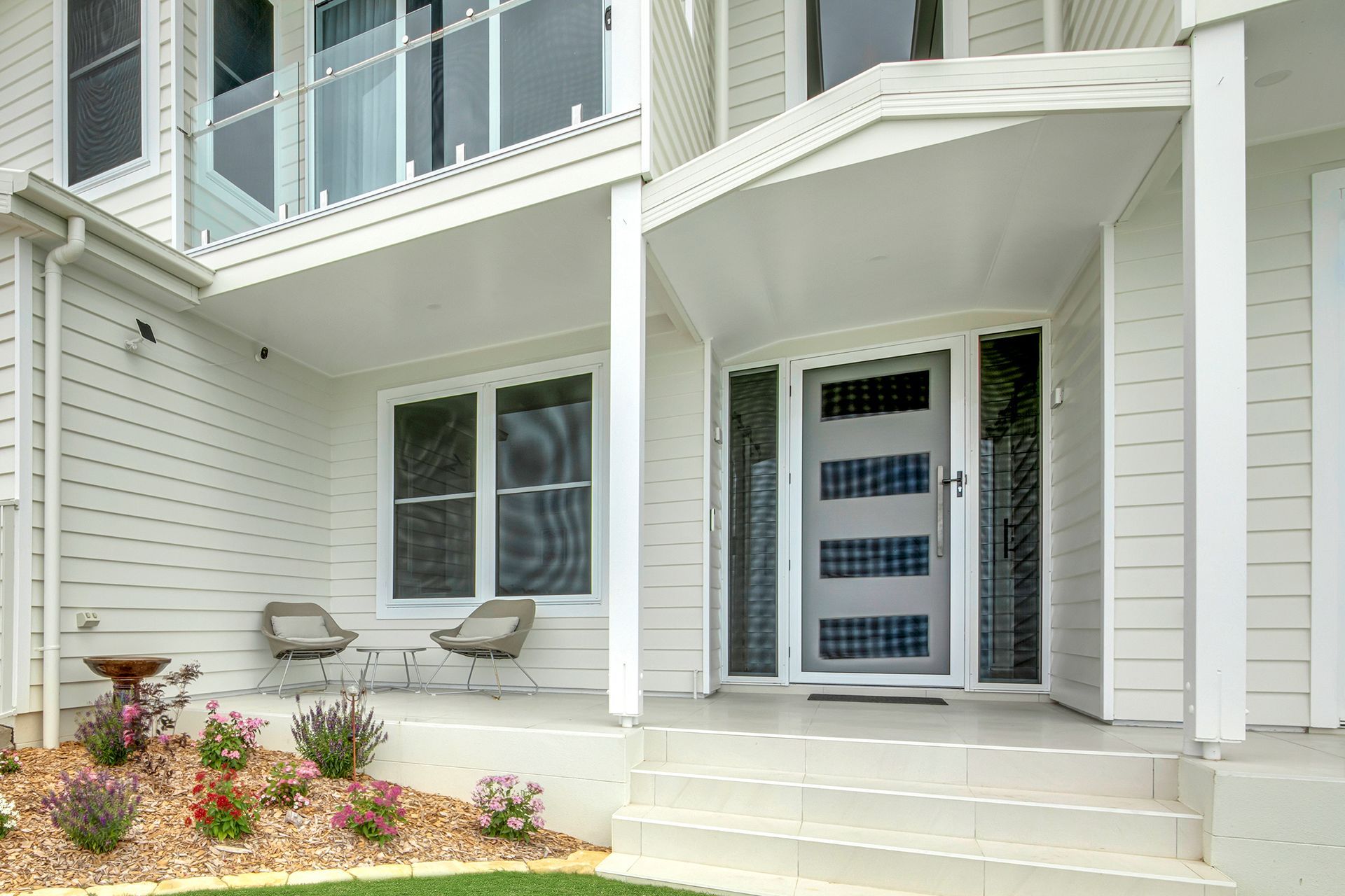 Front entrance of a white house with steps, double front doors, and a small porch seating area — Advantage Screen And Blinds Rockhampton in Rockhampton, QLD