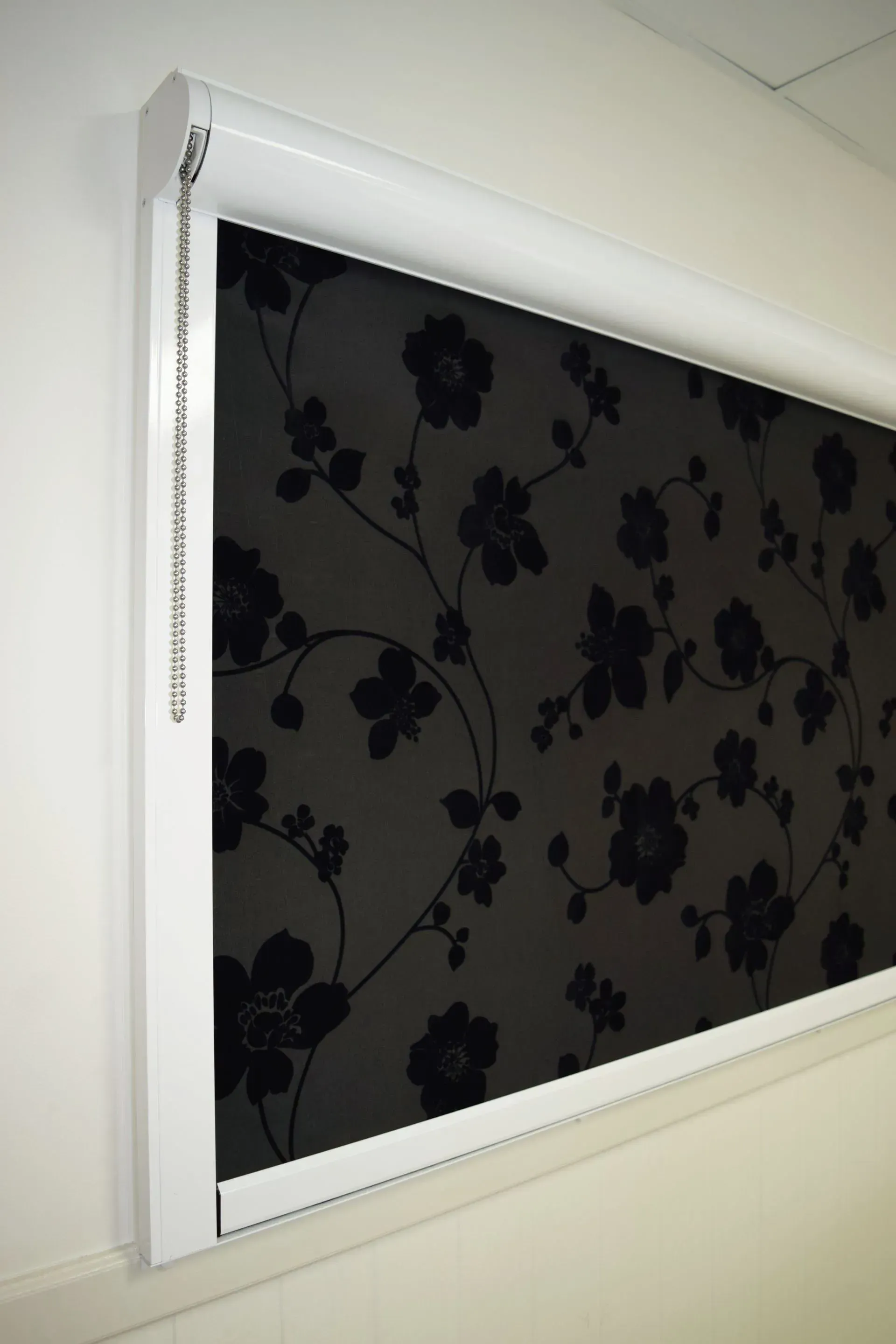 Close-up View of a Black Roller Blind With a Floral Pattern — Advantage Screen And Blinds Rockhampton in Rockhampton, QLD