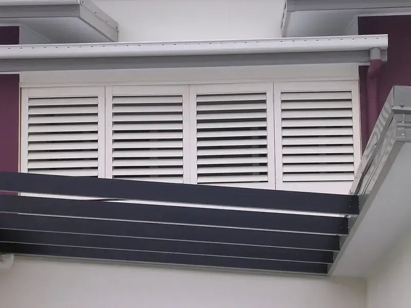 Modern Building Facade With Horizontal White Shutters Covering a Window — Advantage Screen And Blinds Rockhampton in Rockhampton, QLD