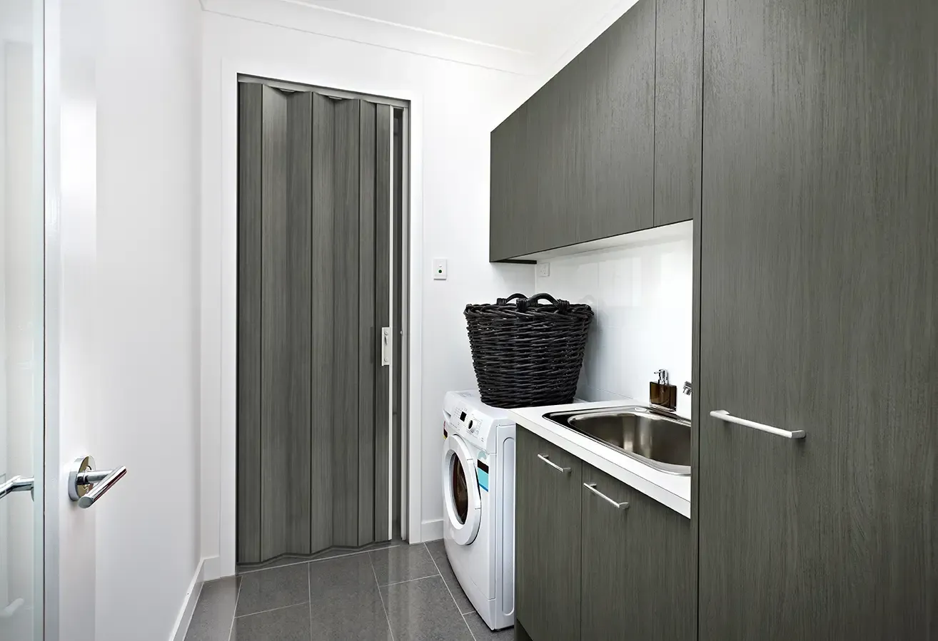 Laundry Room With Cabinets, a Washing Machine, a Sink, and a Folding Door — Advantage Screen And Blinds Rockhampton in Rockhampton, QLD