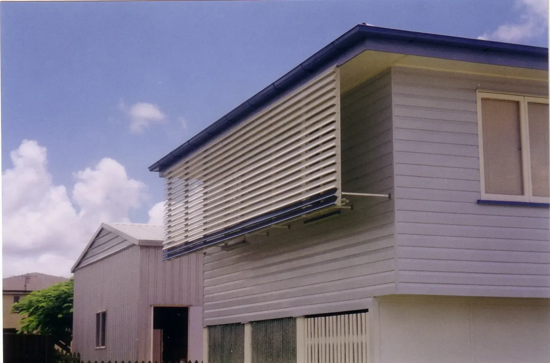 A House With Horizontal Louvered Shutters Extends From Its Window — Advantage Screen And Blinds Rockhampton in Rockhampton, QLD