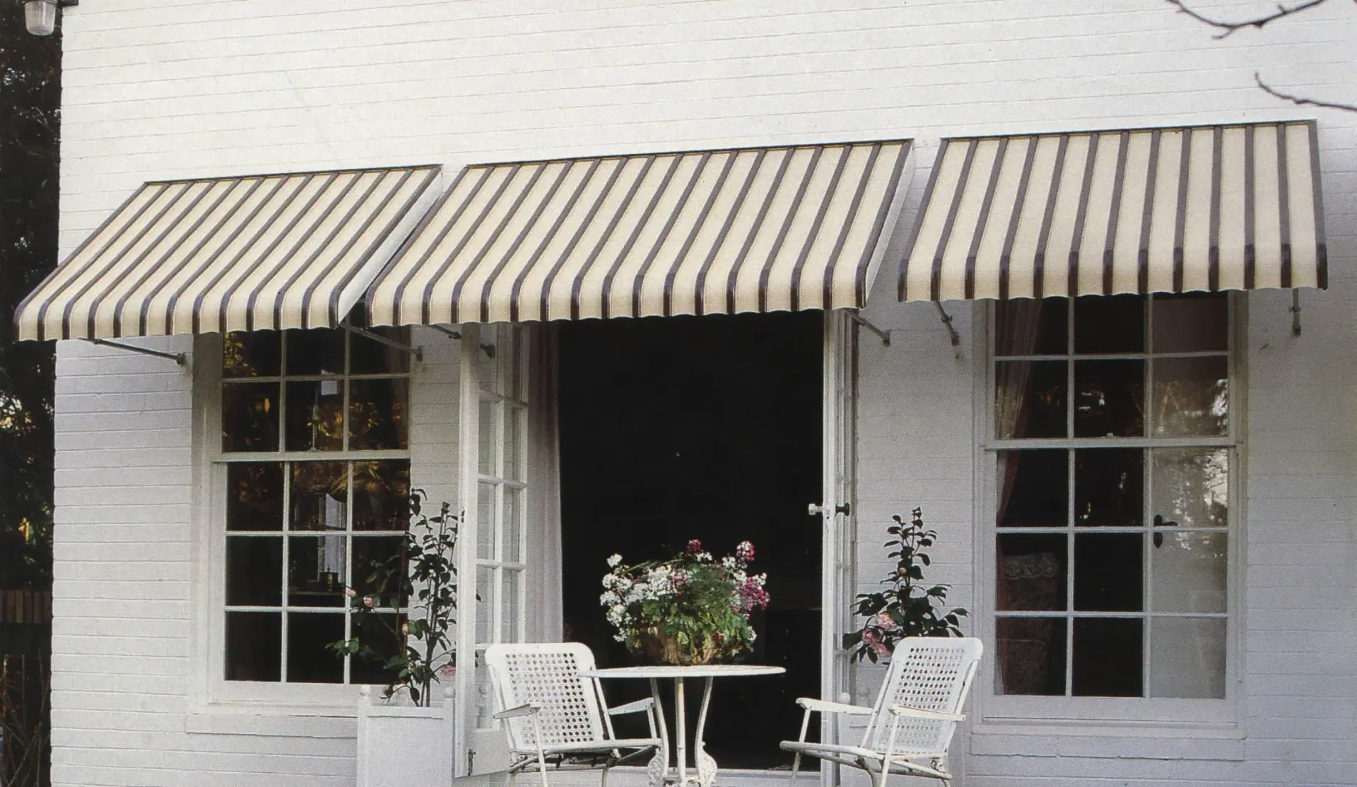 White Brick Exterior With Black-and-white Striped Awnings — Advantage Screen And Blinds Rockhampton in Rockhampton, QLD
