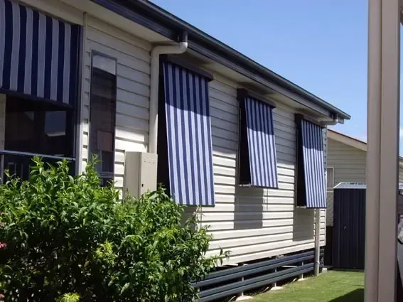 House Exterior With Blue and White Striped Window Awnings and Siding — Advantage Screen And Blinds Rockhampton in Rockhampton, QLD