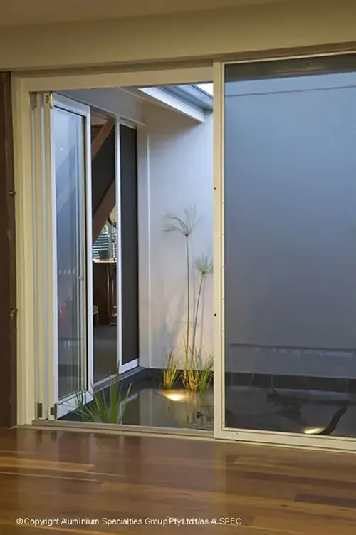 Sliding Glass Door Open to a Modern Patio With Minimalist Plants — Advantage Screen And Blinds Rockhampton in Rockhampton, QLD