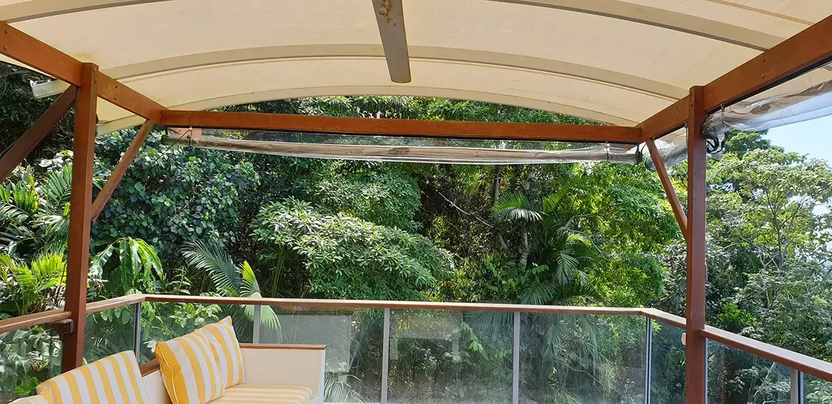 Covered Patio With Glass Railing Overlooks Lush Green Fores — Advantage Screen And Blinds Rockhampton in Rockhampton, QLD