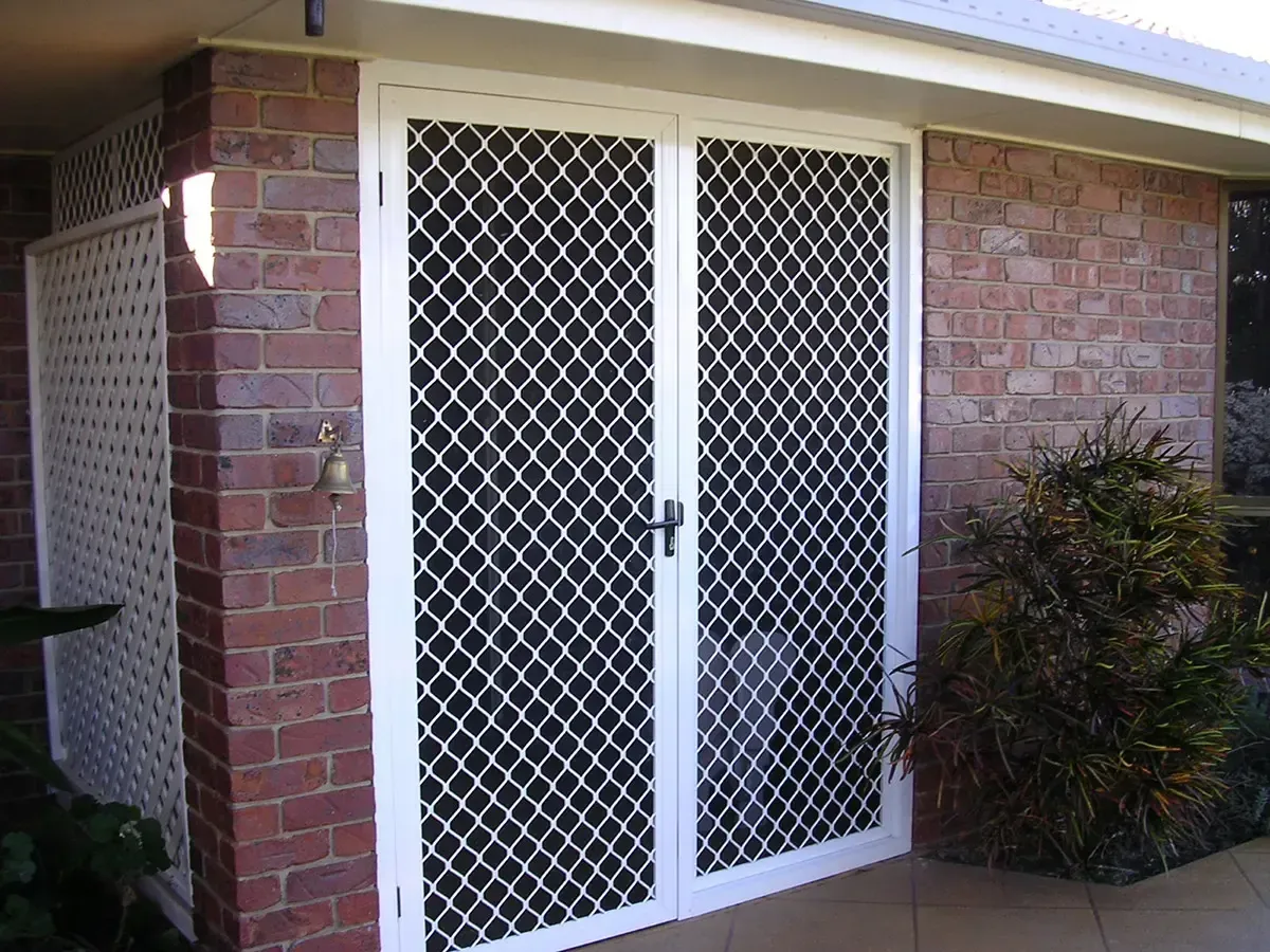 Brick House Features White Double Security Doors With Mesh Patterns — Advantage Screen And Blinds Rockhampton in Rockhampton, QLD