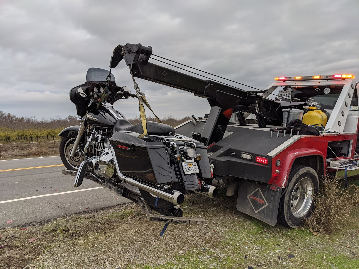 A motorcycle is being towed by a tow truck.