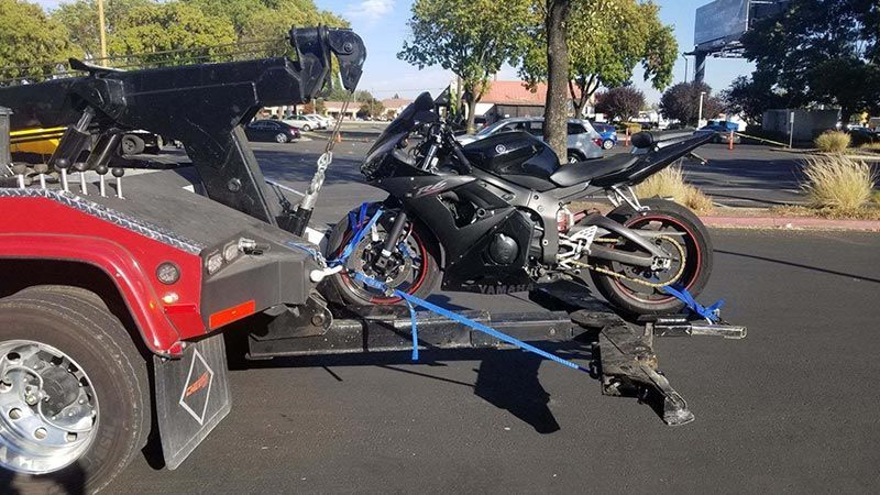 A motorcycle is being towed by a tow truck.