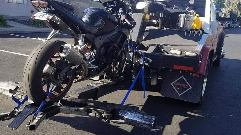 A motorcycle is being towed by a tow truck.