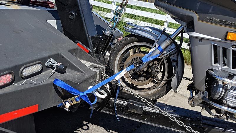 A motorcycle is being towed by a tow truck.