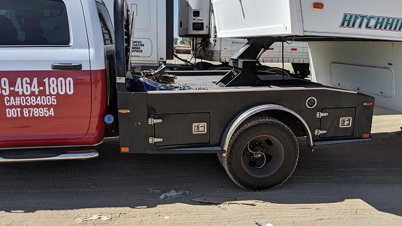 A red and white tow truck is parked on the side of the road.