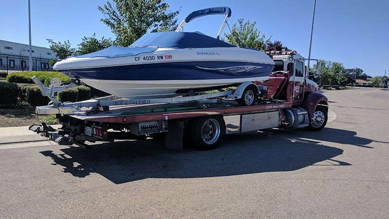 A boat is being towed by a tow truck.