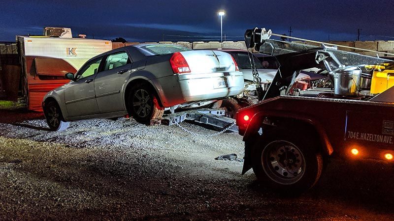 A car is being towed by a tow truck.