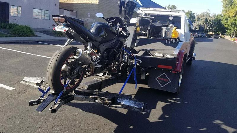 A motorcycle is being towed by a tow truck.
