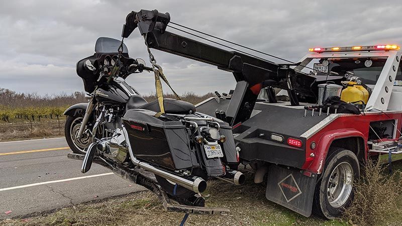 A motorcycle is being towed by a tow truck.