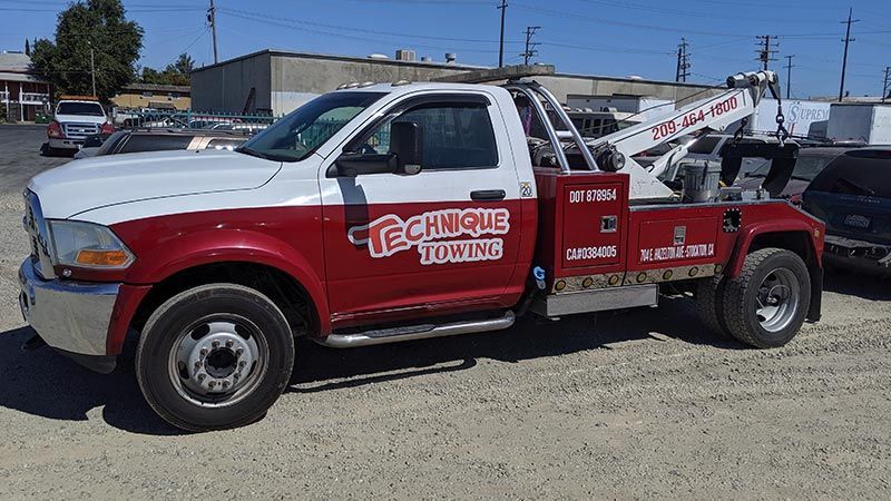 A red and white tow truck is parked in a parking lot