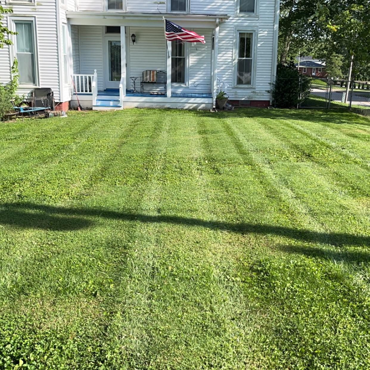 A white house with a lush green lawn in front of it.