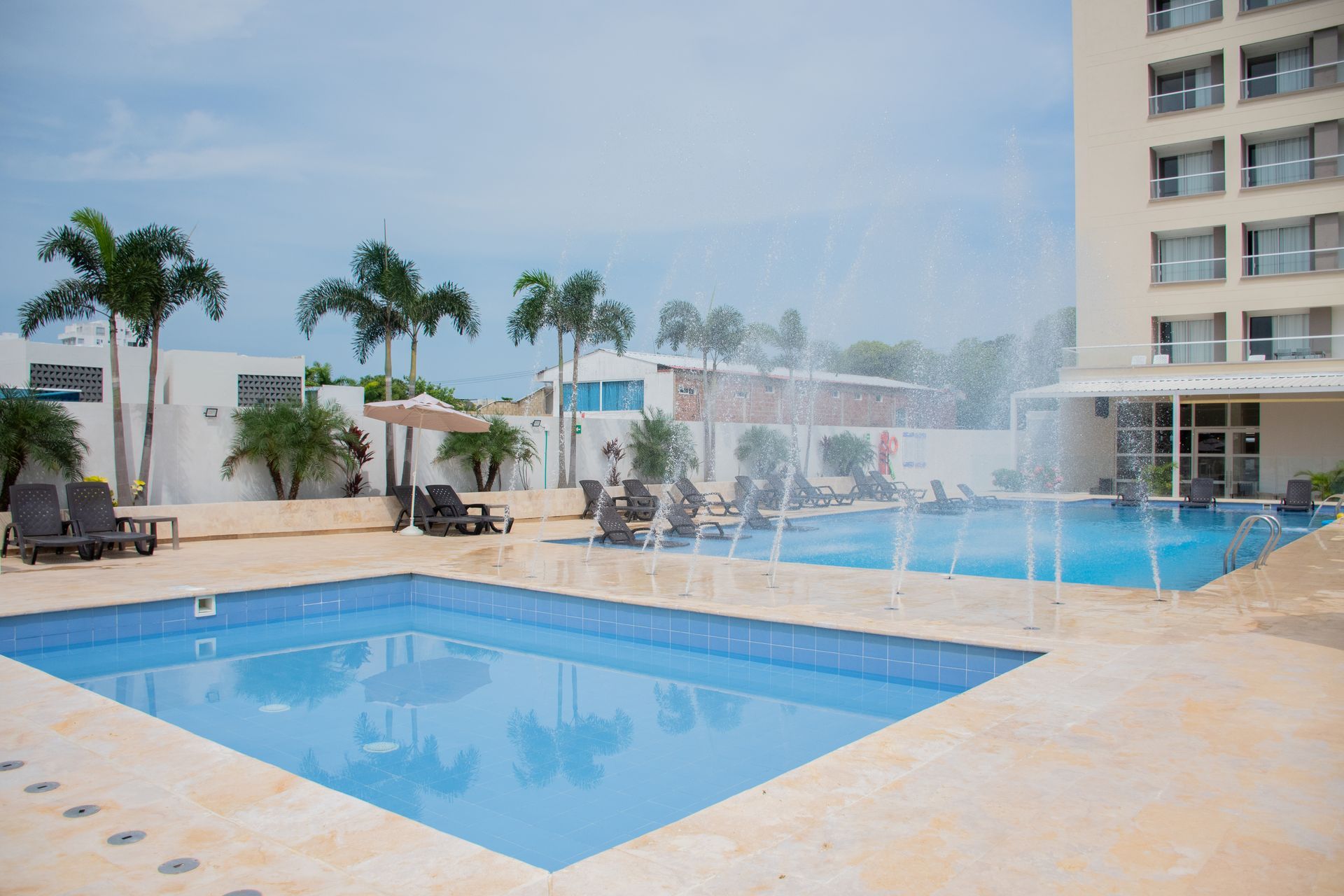 Piscina con una fuente en el medio frente a Ciela Hotel.