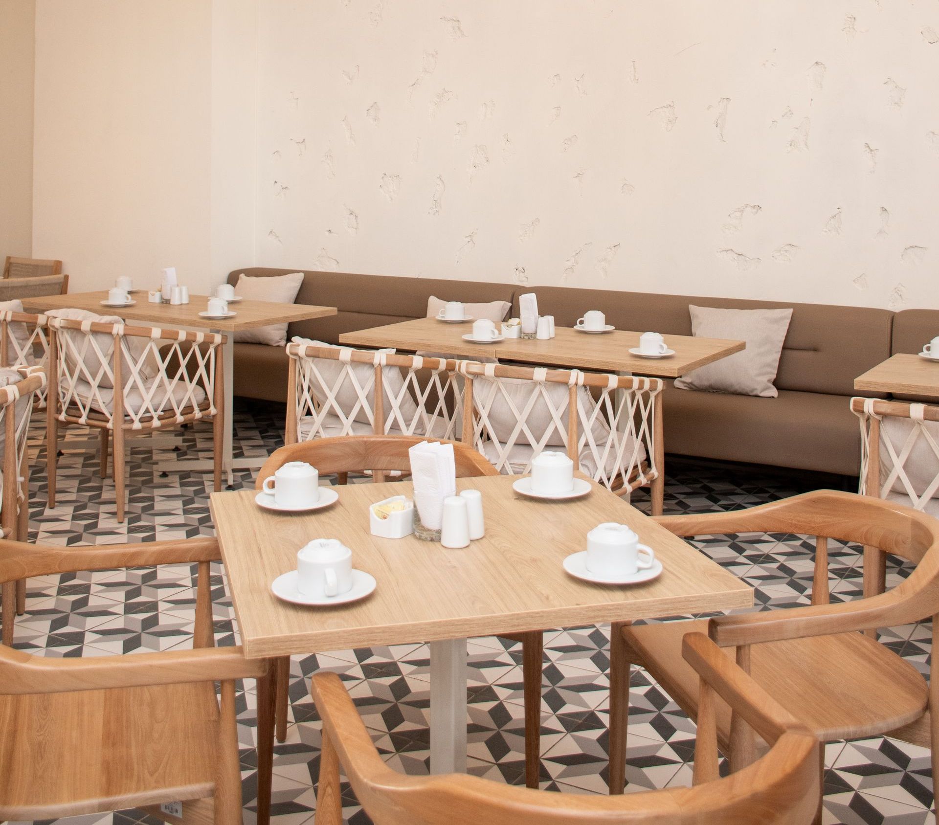 Restaurante con mesas y sillas y un sofá - Ciela Hotel